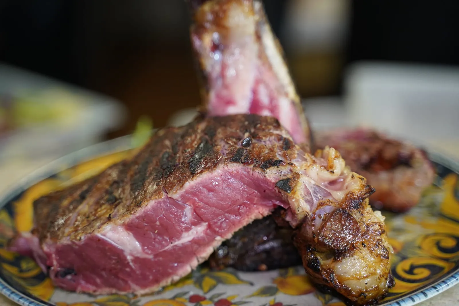 Una bistecca alla fiorentina tagliata al sangue, servita su un piatto decorato