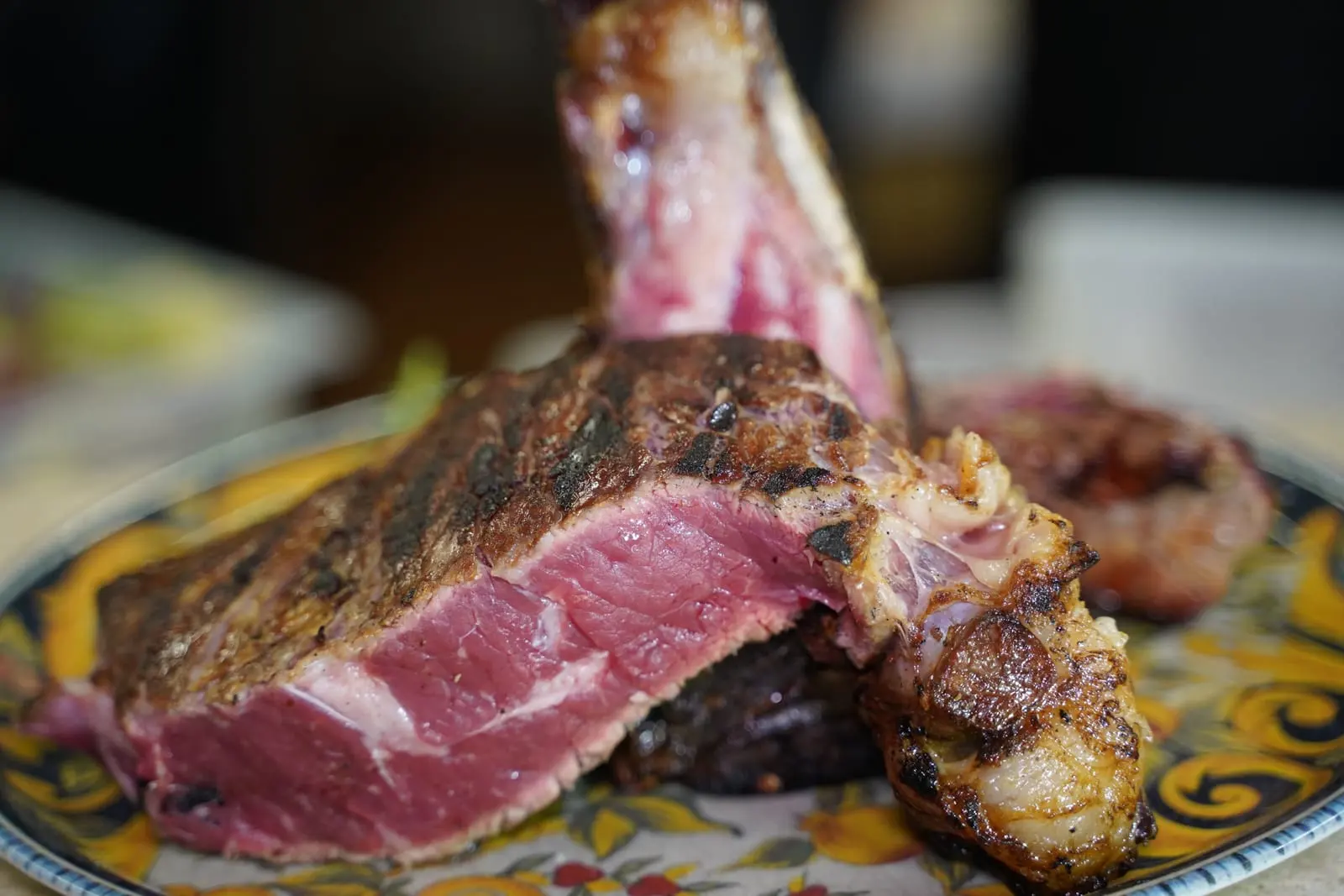 Una bistecca alla fiorentina tagliata al sangue, servita su un piatto decorato
