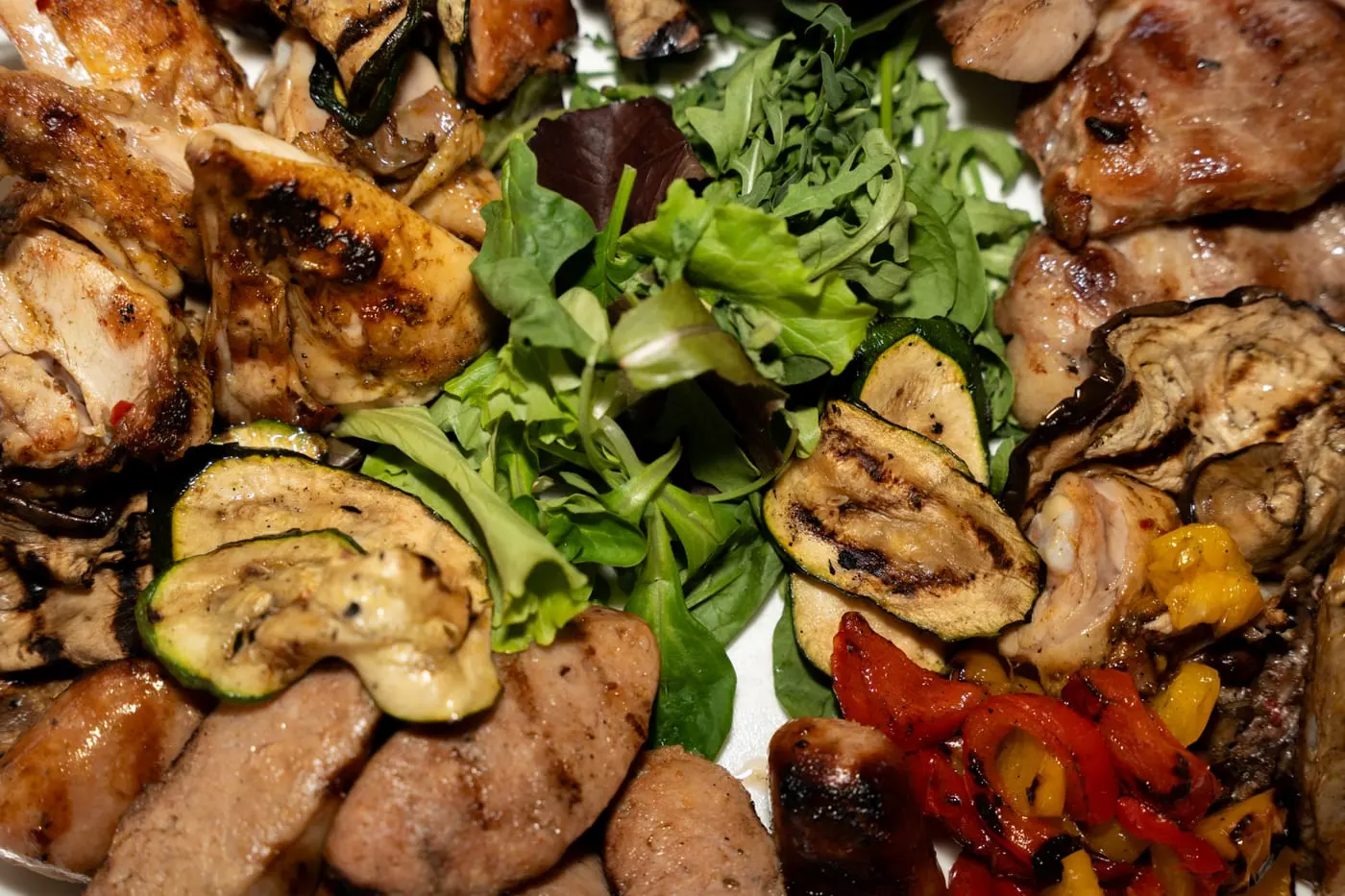 Carne alla griglia con verdure grigliate e insalata, vista da vicino