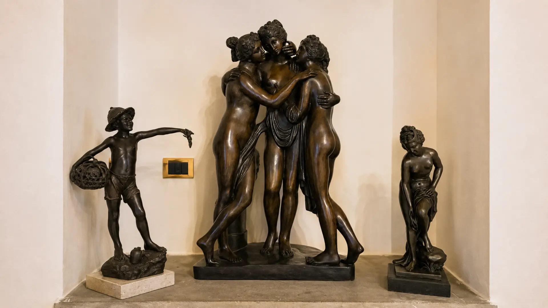 Le sculture in bronzo nella nicchia di una suite: le Tre Grazie al centro, il pescatore col cesto a sinistra e una figura femminile a destra