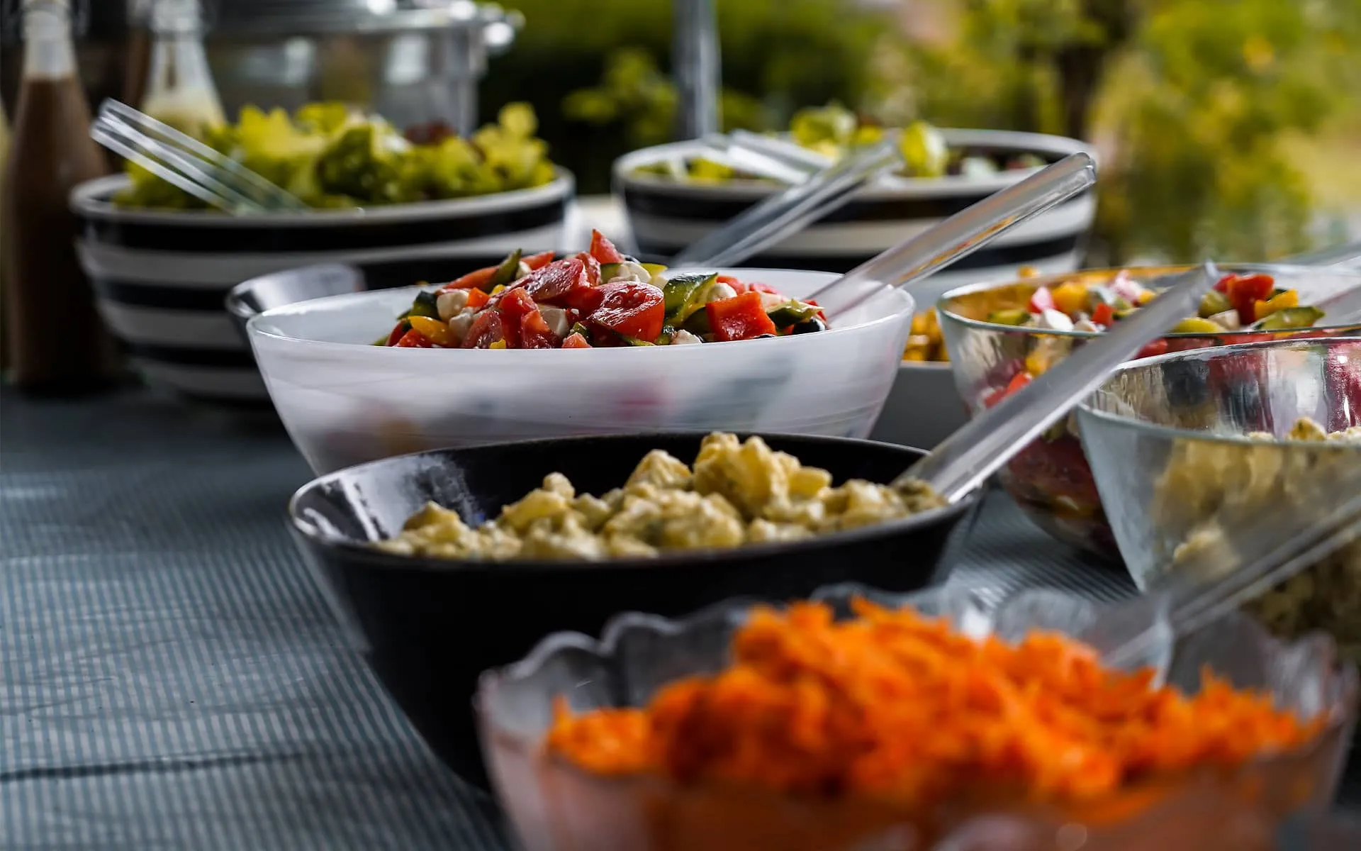 Il buffet di un evento in villa, con le ciotole di verdure e i contorni