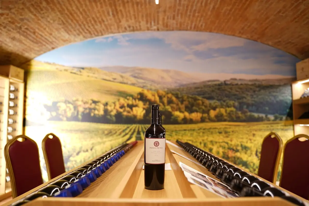 La volta in mattoni di Cantina 18, con le bottiglie e il murale toscano